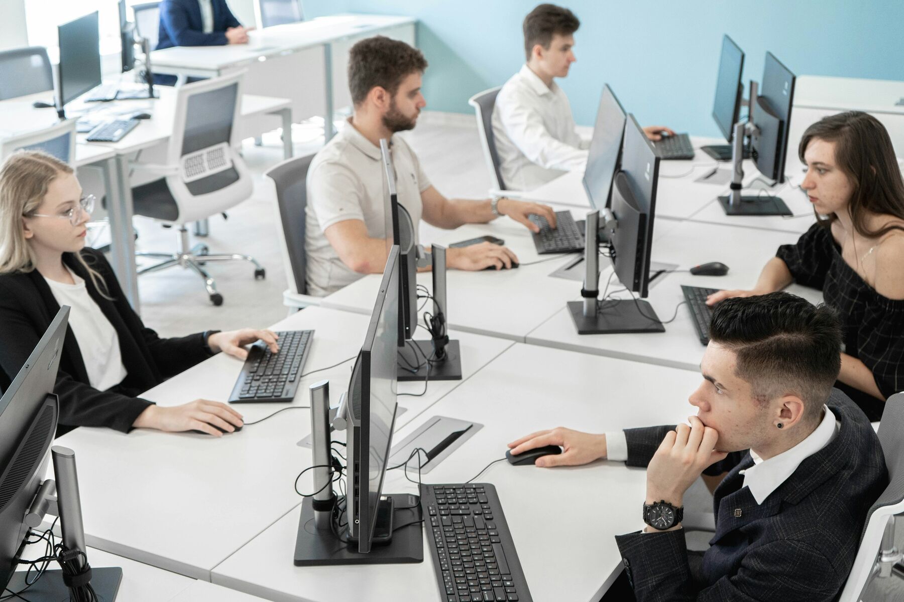 Equipo de trabajo en oficina compartida frente a sus computadores